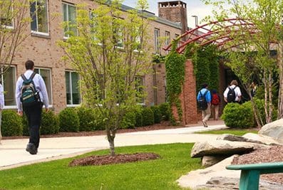 Students walking near school building.