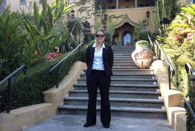 Woman in suit standing on steps.