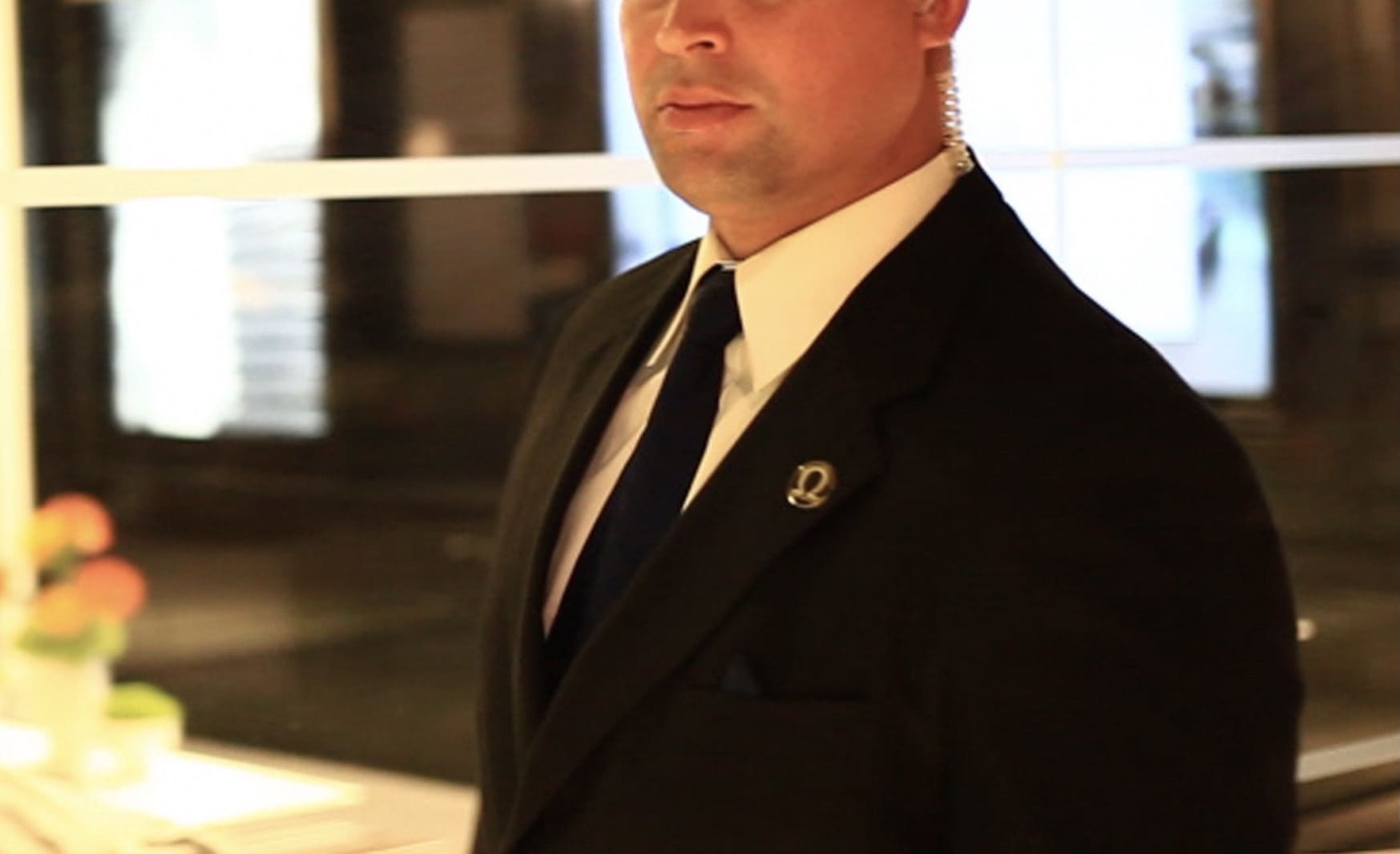 A man in a suit and tie standing next to a building.